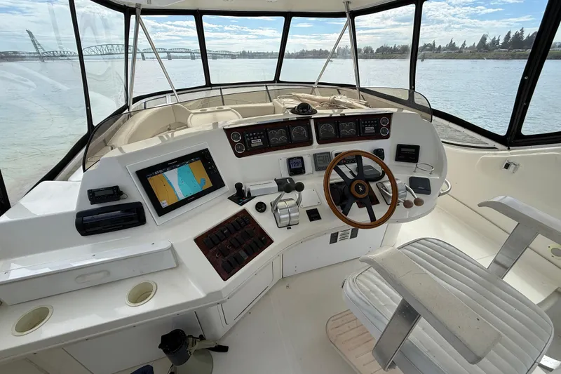Slide: The Image of 1999 Sea Ray 560 Sedan Bridge helm with navigation equipment and panoramic water view. - 16