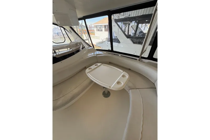 Slide: The Image of 1999 Sea Ray 560 Sedan Bridge interior with curved seating and small table. - 20