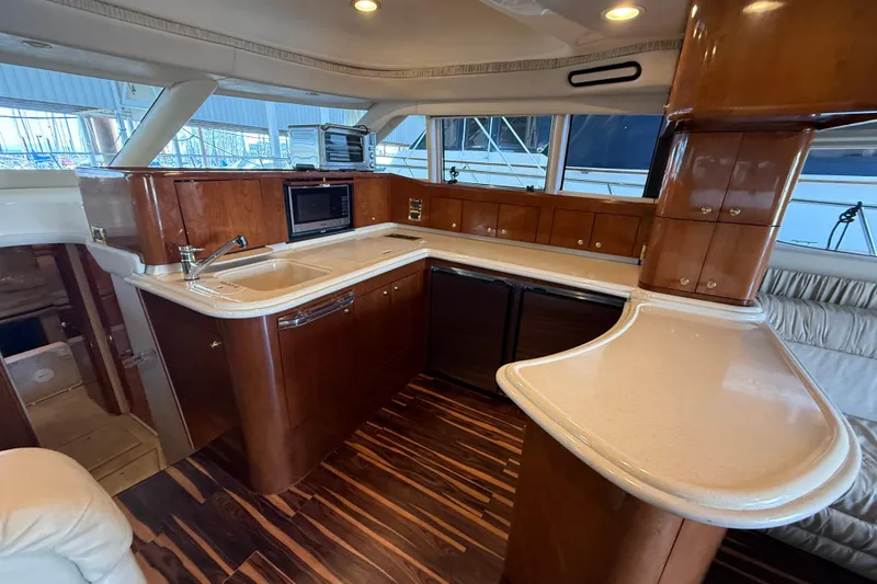 Slide: The Image of Luxurious kitchen interior of 1999 Sea Ray 560 Sedan Bridge yacht with wood cabinetry. - 28