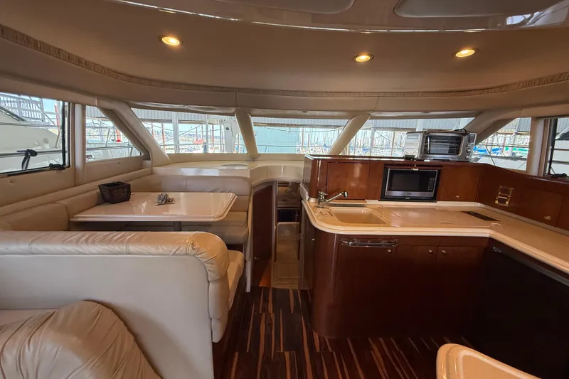 Slide: The Image of Luxurious interior of a 1999 Sea Ray 560 Sedan Bridge yacht with kitchen and dining area. - 30