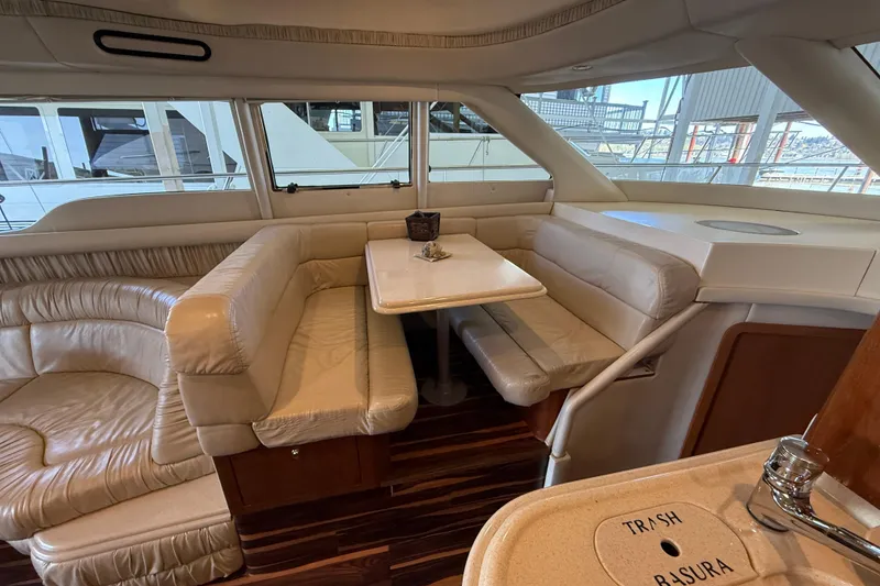 Slide: The Image of Interior of 1999 Sea Ray 560 Sedan Bridge with plush seating and dining table. - 32