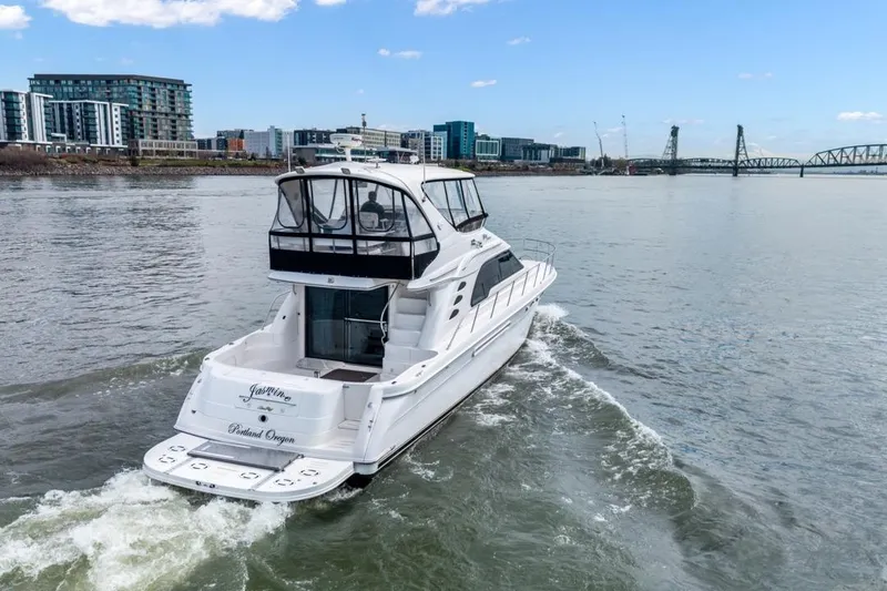 Slide: The Image of 1999 Sea Ray 560 Sedan Bridge yacht cruising near urban waterfront and bridge. - 8