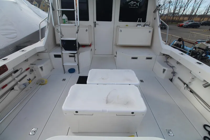 Slide: The Image of 1999 Cabo 35 Flybridge boat deck with storage compartments and ladder. - 3