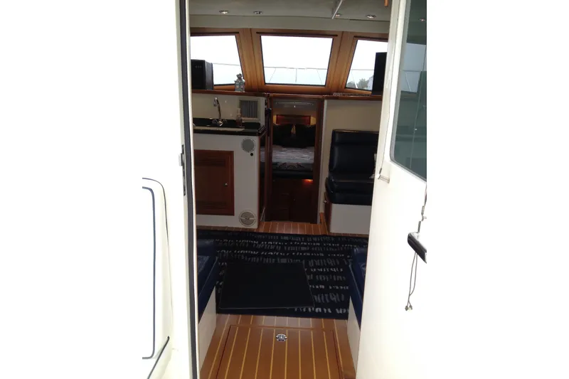 Slide: The Image of Interior view of 1999 Cabo 35 Flybridge yacht, featuring wood flooring and seating area. - 5