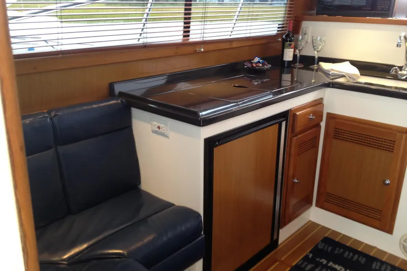 Slide: The Image of Interior of 1999 Cabo 35 Flybridge yacht with leather seating and kitchenette. - 6