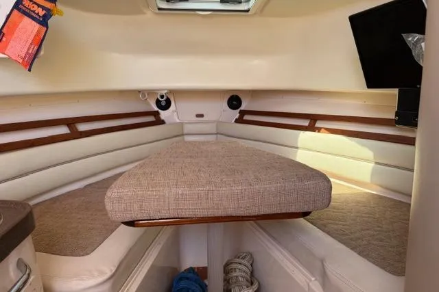 Slide: The Image of 2007 Grady-White Marlin 300 cabin interior with cushioned seating and wooden accents. - 23