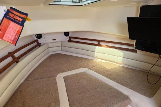 Slide: The Image of Interior cabin of 2007 Grady-White Marlin 300 boat, featuring cozy seating and a mounted TV. - 24