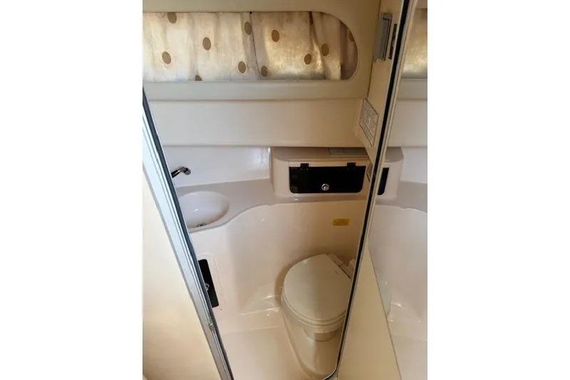 Slide: The Image of 2007 Grady-White Marlin 300 boat bathroom interior with sink, toilet, and mirror. - 25