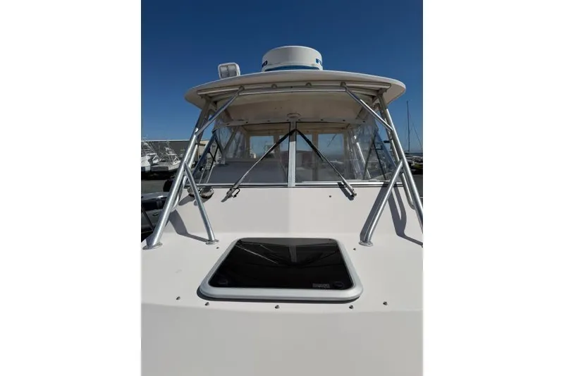 Slide: The Image of 2007 Grady-White Marlin 300 boat, front view with windshield and radar, under clear blue sky. - 40
