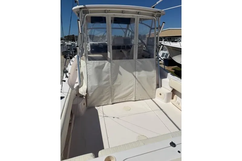 Slide: The Image of 2007 Grady-White Marlin 300 boat with enclosed cockpit, docked under clear blue sky. - 8