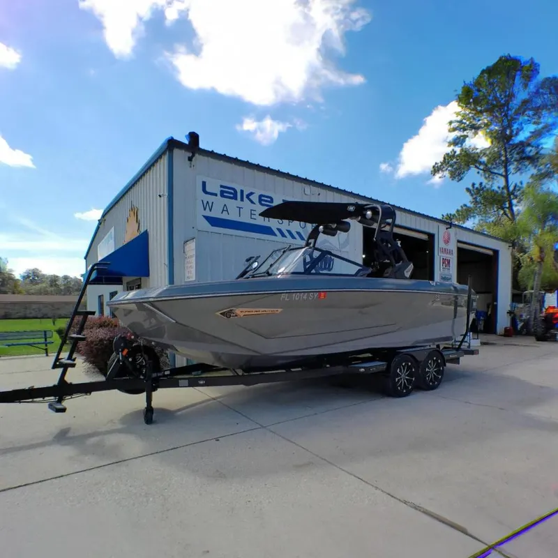 The Image of 2021 Nautique Super Air Nautique G23 Coastal Edition boat on trailer outside dealership. - 0
