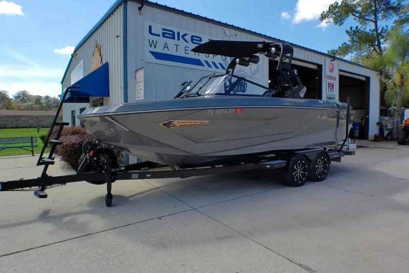 The Image of 2021 Nautique Super Air Nautique G23 Coastal Edition boat on trailer outside dealership. - 1