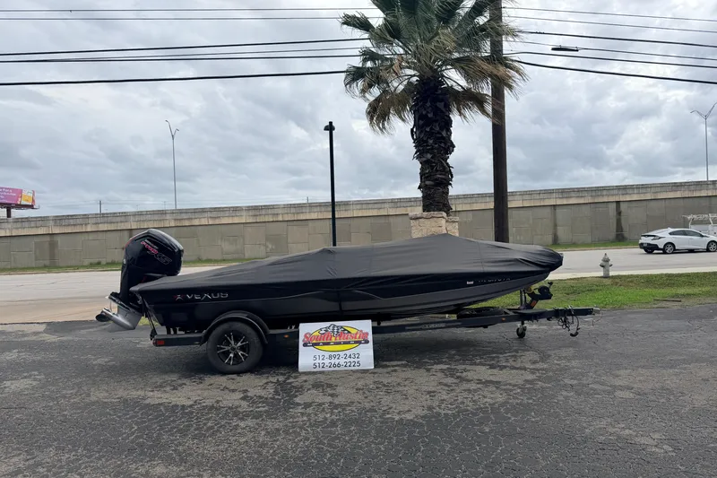 Slide: The Image of 2020 Vexus AVX1880 boat with cover, parked outdoors near a palm tree. - 1