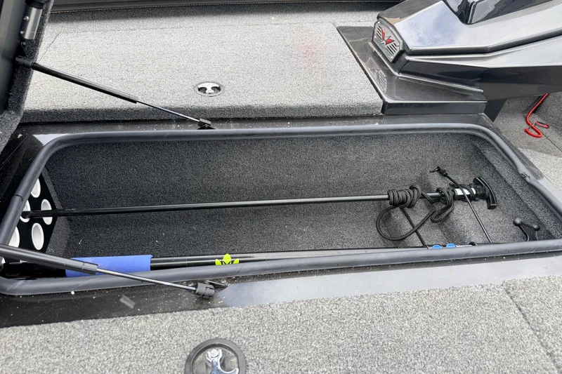 Slide: The Image of Open storage compartment in a 2020 Vexus AVX1880 boat, featuring fishing rod storage. - 26