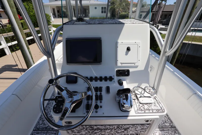 Slide: The Image of Center console of a 2014 Canyon Bay 2400 boat with steering wheel and controls. - 18