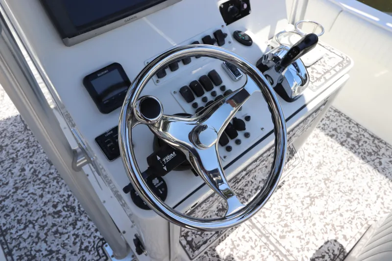 Slide: The Image of Steering console of 2014 Canyon Bay 2400 boat with chrome wheel and controls. - 19