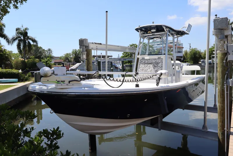 Slide: The Image of 2014 Canyon Bay 2400 boat docked in a sunny marina setting. - 2