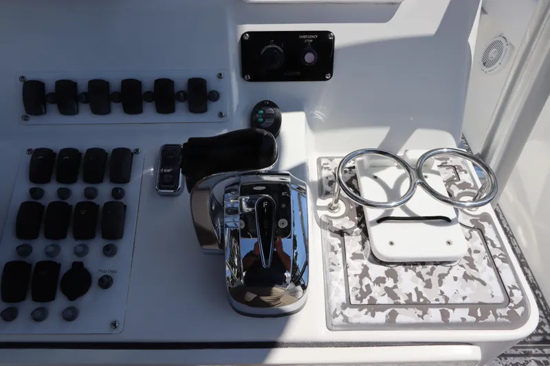 Slide: The Image of Control panel of a 2014 Canyon Bay 2400 boat with switches and throttle. - 20