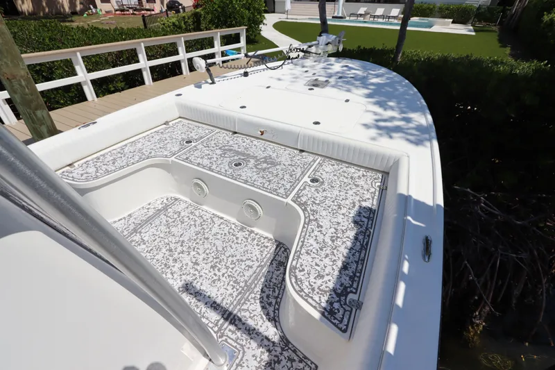 Slide: The Image of 2014 Canyon Bay 2400 boat deck with patterned flooring, docked near a wooden railing. - 26
