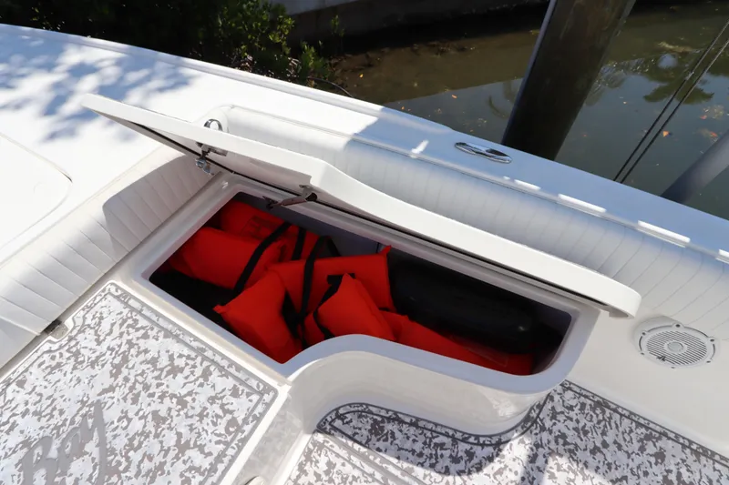 Slide: The Image of Open storage compartment on 2014 Canyon Bay 2400 boat with life jackets inside. - 29