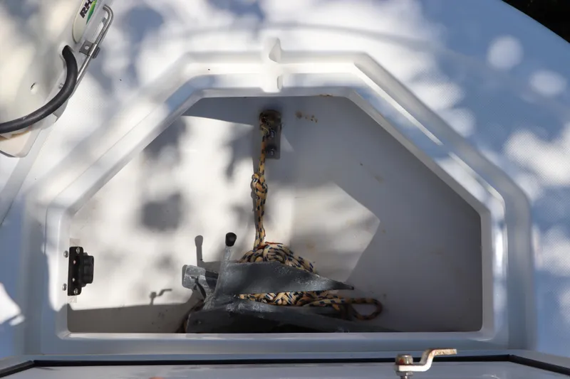 Slide: The Image of Anchor storage compartment on a 2014 Canyon Bay 2400 boat, featuring rope and anchor. - 33