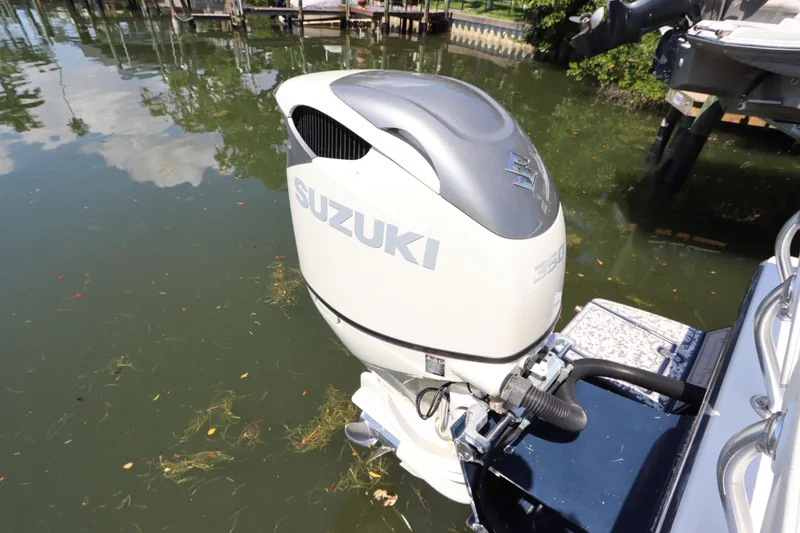 Slide: The Image of Outboard motor on a 2014 Canyon Bay 2400 boat, docked in calm waters. - 8