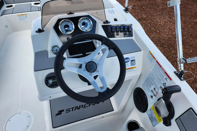 Slide: The Image of 2026 Starcraft SV 16 OB boat dashboard with steering wheel and control panel. - 16