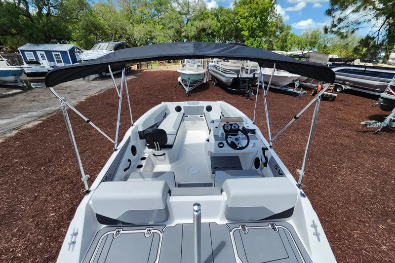 Slide: The Image of 2026 Starcraft SV 16 OB boat with canopy, parked outdoors among other boats. - 28