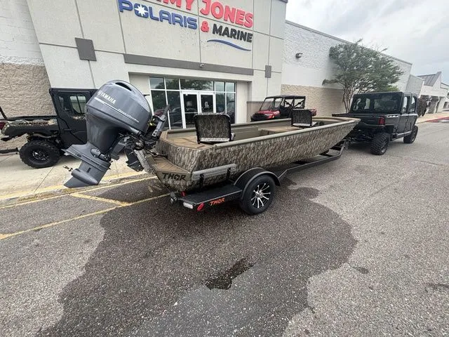 Slide: The Image of 2026 Thor Boats 1860 Lake Hammer Elite in front of a marine store. - 2