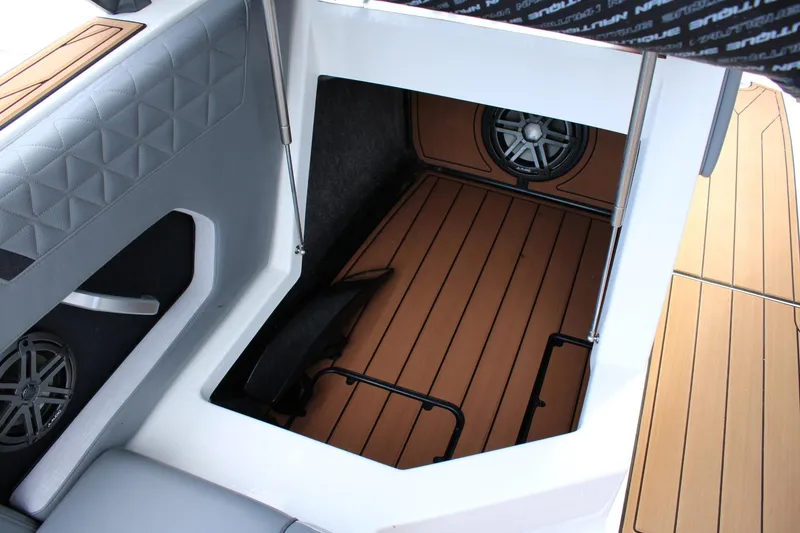 Slide: The Image of 2023 Nautique Super Air Nautique GS20 storage compartment with speaker and cushioned interior. - 18