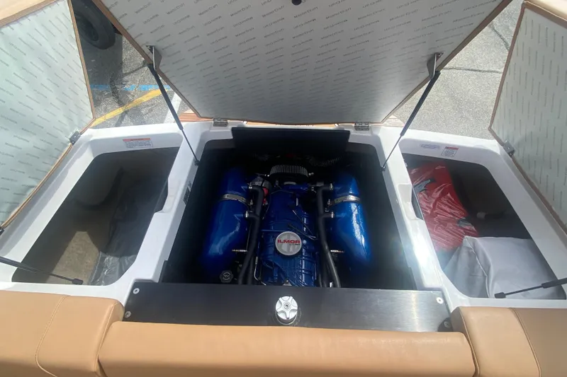 Slide: The Image of 2023 MasterCraft NXT21 boat engine compartment with open hatches, showcasing blue engine components. - 12