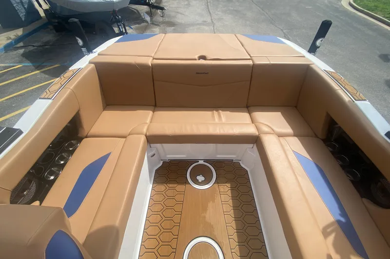 Slide: The Image of 2023 MasterCraft NXT21 boat interior with tan and blue seating, hexagonal flooring. - 15