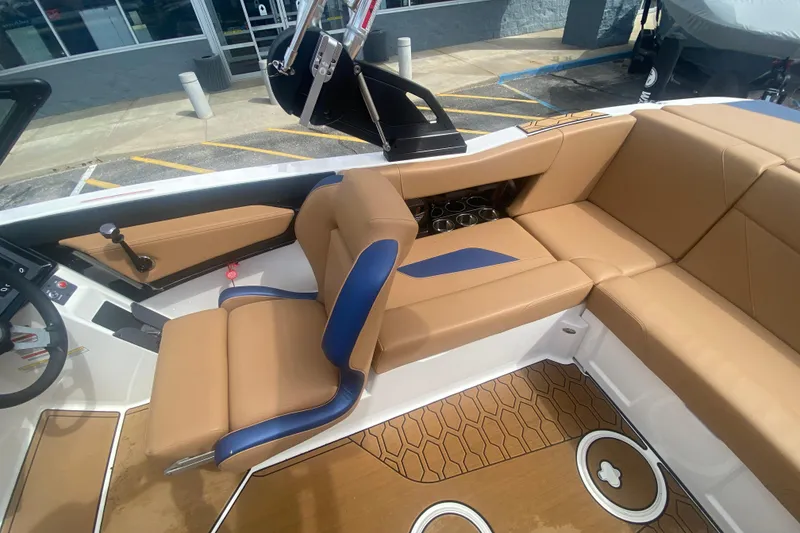 Slide: The Image of 2023 MasterCraft NXT21 boat interior with tan and blue seating, modern design. - 16