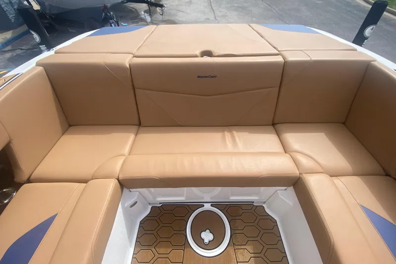 Slide: The Image of 2023 MasterCraft NXT21 boat interior with tan leather seating and hexagonal floor design. - 17