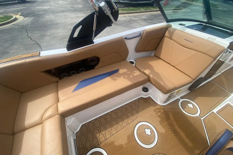 Slide: The Image of 2023 MasterCraft NXT21 boat interior with tan seating and stylish flooring design. - 18