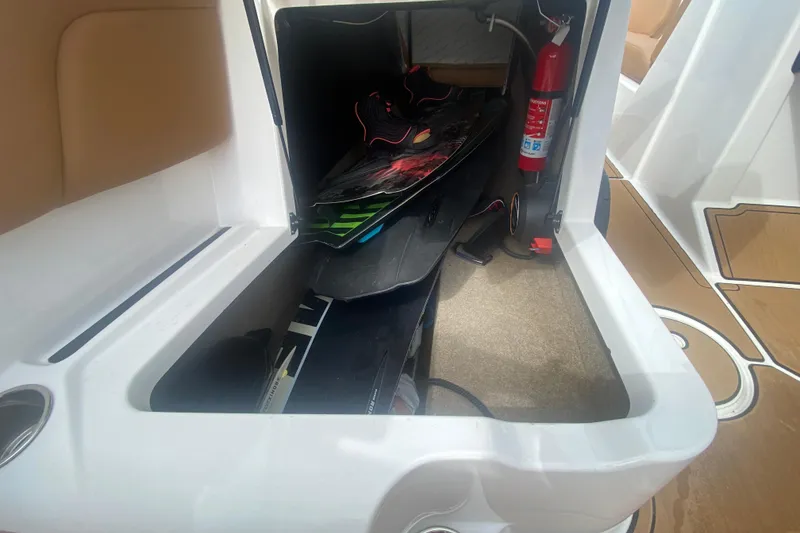 Slide: The Image of 2023 MasterCraft NXT21 boat storage compartment with wakeboard and fire extinguisher. - 20