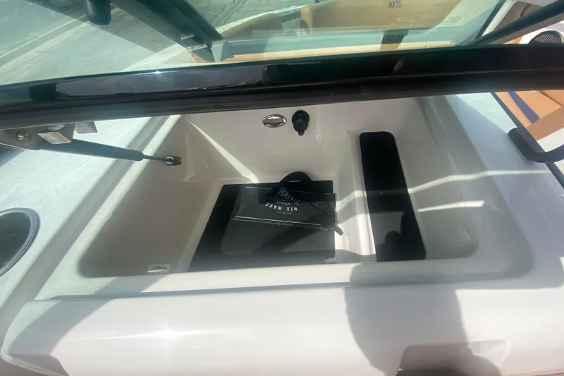 Slide: The Image of 2023 MasterCraft NXT21 boat storage compartment with open lid and visible interior. - 23