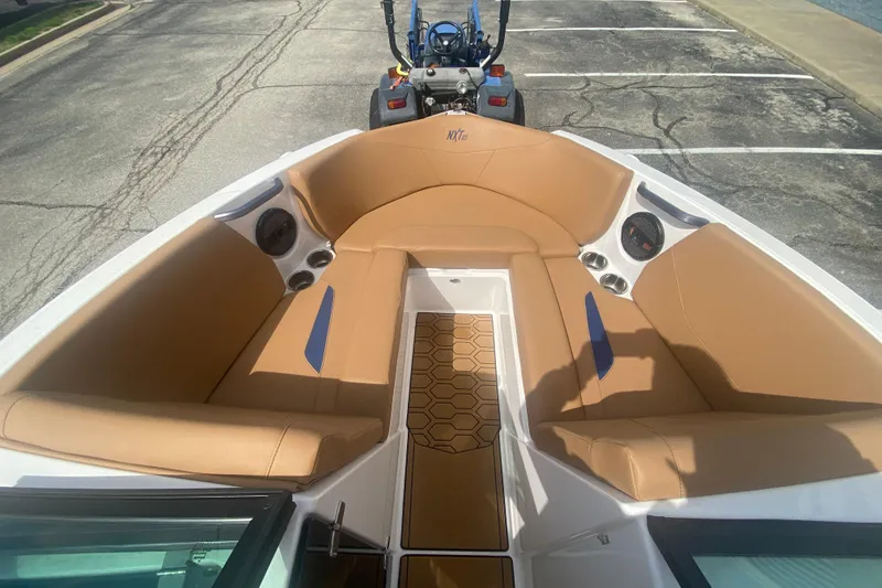Slide: The Image of 2023 MasterCraft NXT21 boat interior with tan seating and hexagonal floor design. - 24