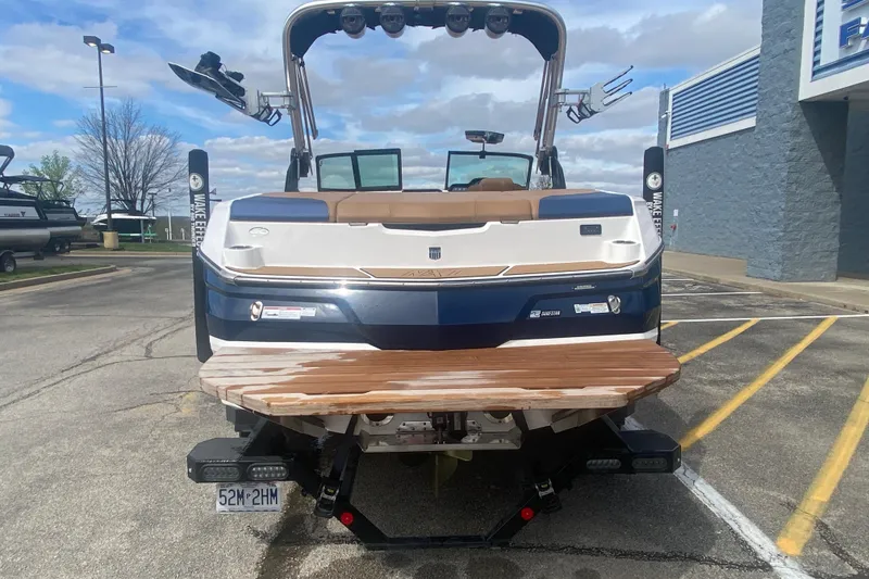 Slide: The Image of 2023 MasterCraft NXT21 boat, rear view, parked outdoors on a sunny day. - 4