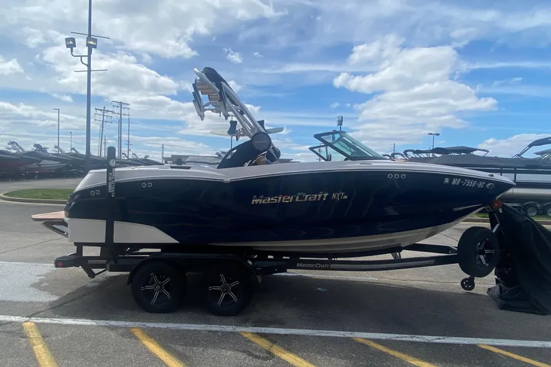 Slide: The Image of 2023 MasterCraft NXT21 boat on trailer under cloudy sky. - 7