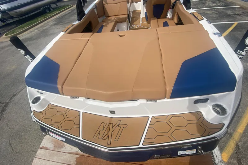 Slide: The Image of 2023 MasterCraft NXT21 boat with tan and blue upholstery, showcasing sleek design and spacious seating. - 9