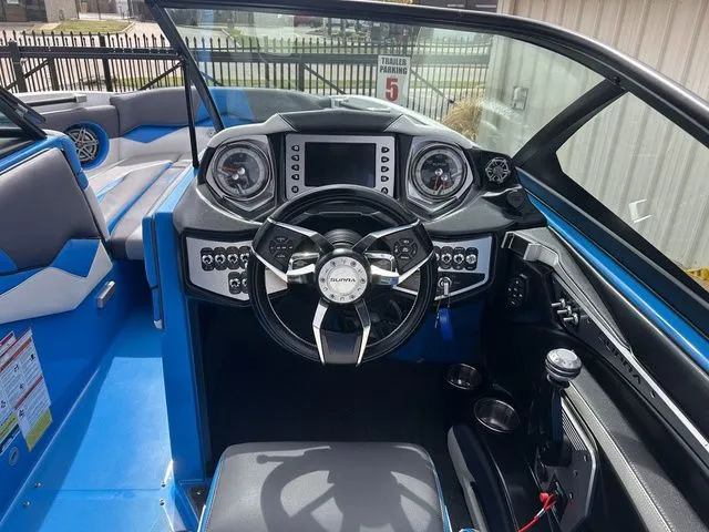 Slide: The Image of Interior of a blue 2018 Supra SL boat with modern dashboard. - 16