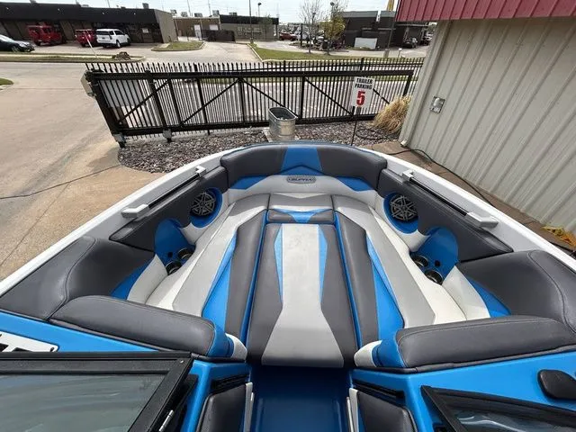 Slide: The Image of 2018 Supra SL boat with blue and gray seating at dock. - 22