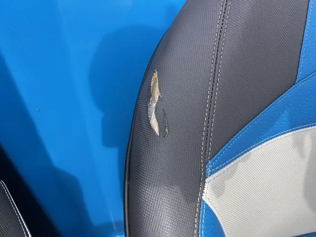 Slide: The Image of Damaged seat upholstery of a 2018 Supra SL with blue and gray design. - 31
