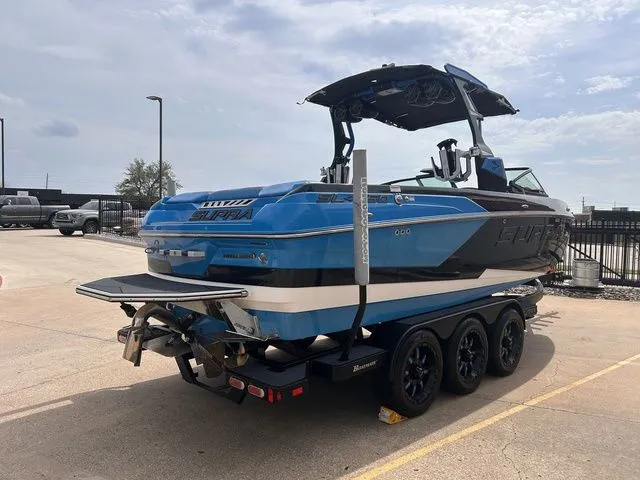 Slide: The Image of 2018 Supra SL boat on trailer, blue and black, parked outdoors. - 8