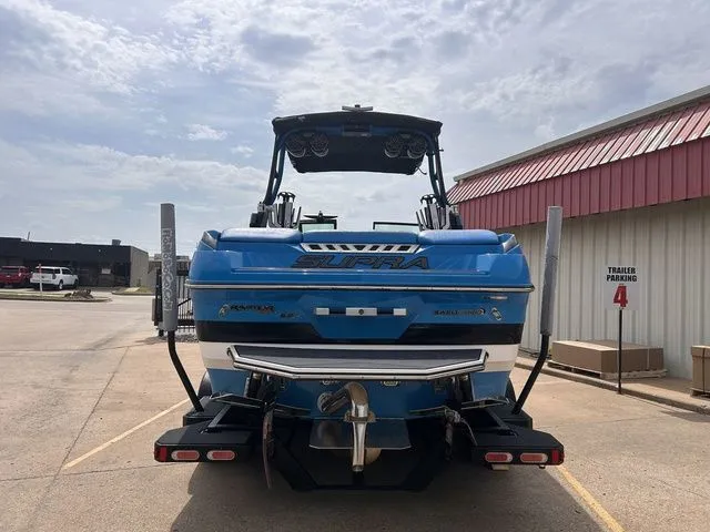 Slide: The Image of Rear view of a blue 2018 Supra SL boat in a parking lot. - 9