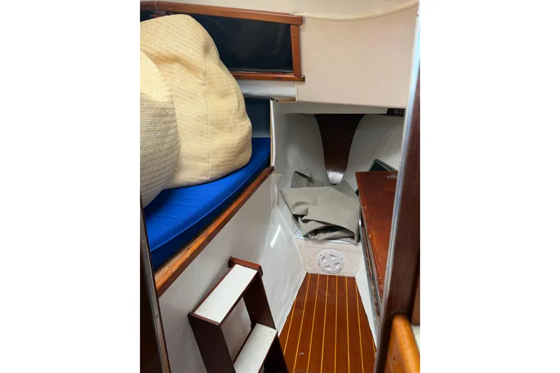Slide: The Image of Interior cabin of a 1989 Gemini 3000 boat with wooden flooring and blue cushions. - 12