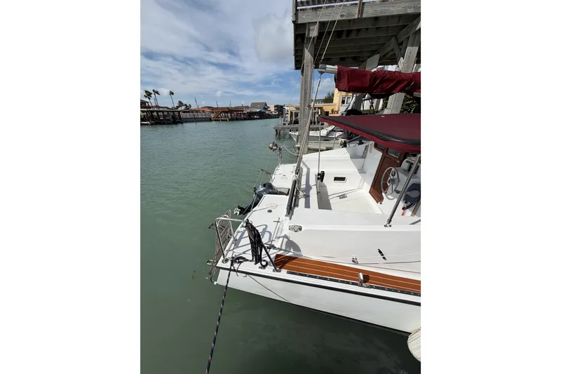 Slide: The Image of 1989 Gemini 3000 sailboat docked in a serene marina setting. - 4