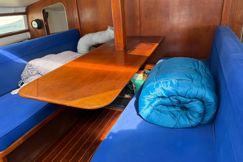 Slide: The Image of Interior of 1989 Gemini 3000 sailboat with blue seating and wooden table. - 7