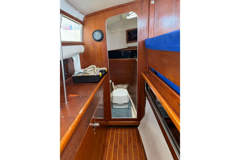 Slide: The Image of Interior of 1989 Gemini 3000 boat with wooden finish and compact amenities. - 8